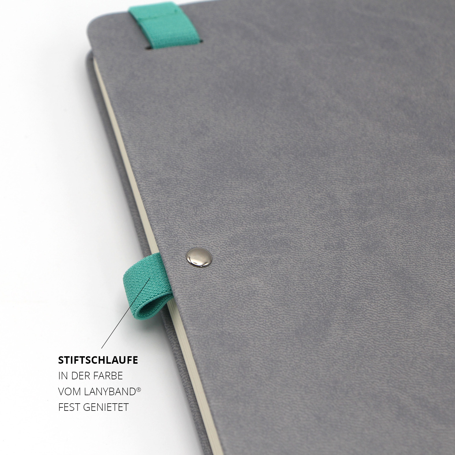 Metallniete und türkisfarbene Stiftschlaufe am Rand des Notizbuchs – abgestimmt auf das Lanyband.