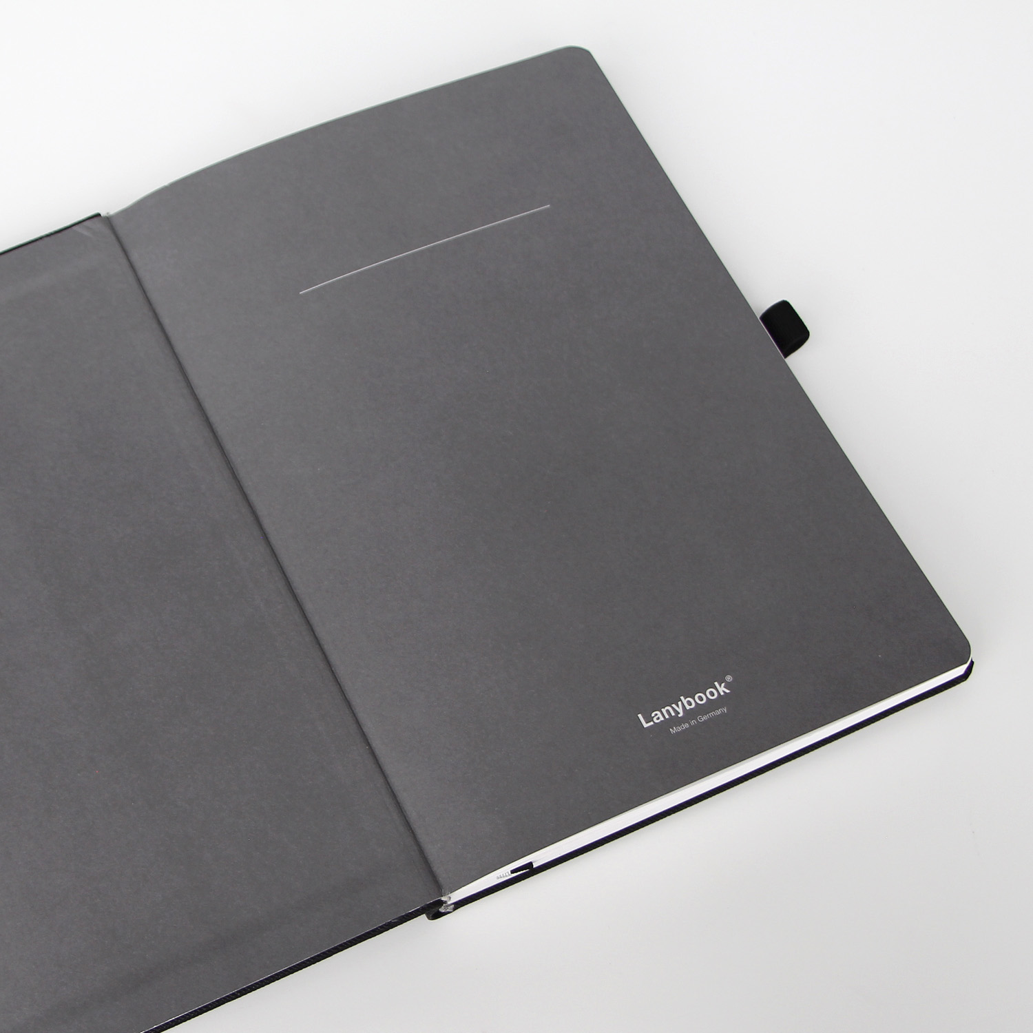 Geöffnete erste Seite eines Lanybook®-Notizbuchs mit schlichtem, grauem Inneneinband und dezenter Lanybook®-Prägung.