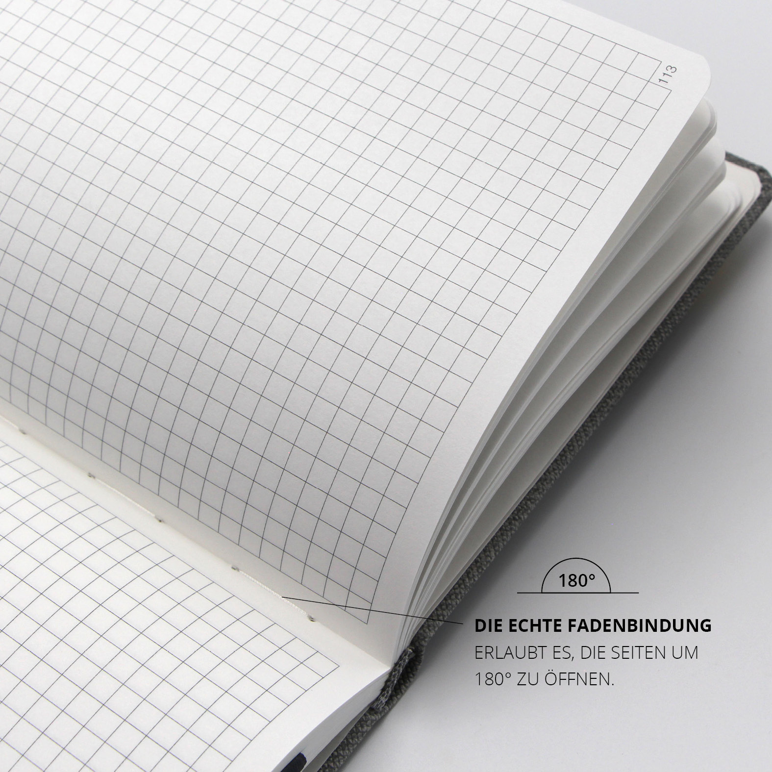 Geöffnete Doppelseite mit kariertem Recyclingpapier, echte Fadenbindung für 180° flaches Aufschlagen.