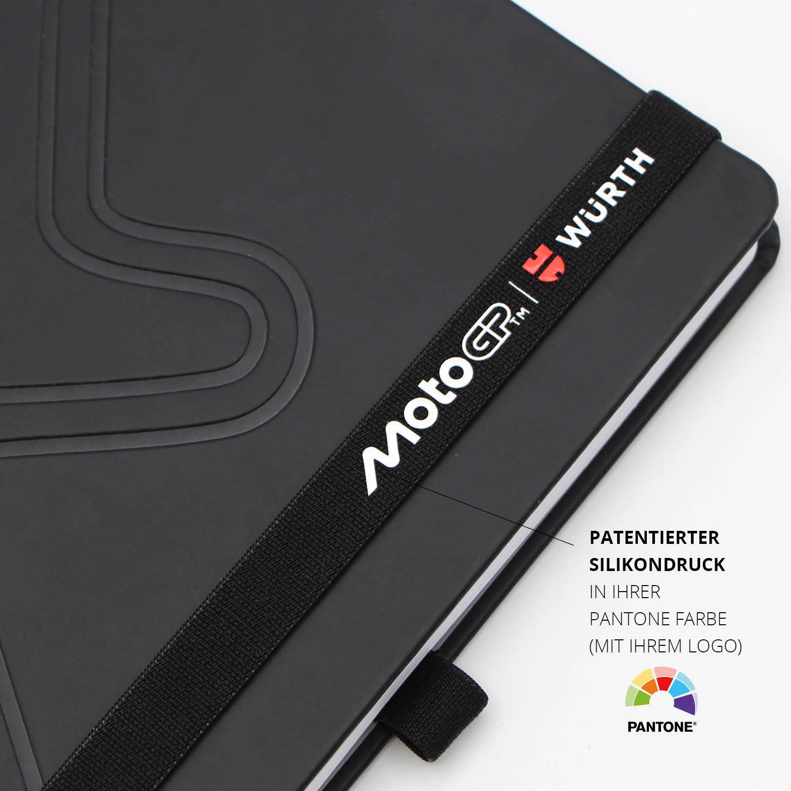 Schwarzes Lanybook® Notizbuch im A5-Format mit schwarzem Lanyband und weiß-rotem MotoGP™ x Würth Logo im patentierten Silikondruck, detailreiche Prägung auf dem Einband sichtbar.