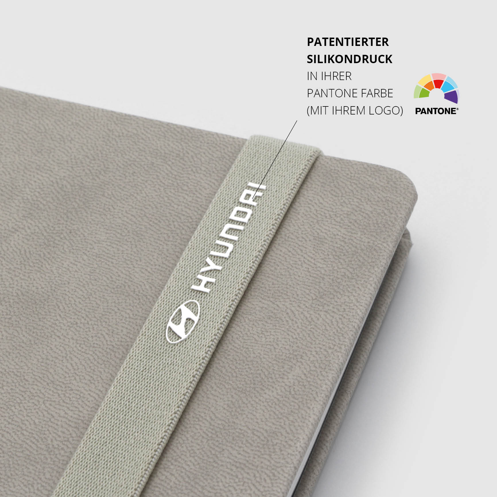 Hyundai-Notizbuch mit patentiertem Silikondruck – Beiges Notizbuch mit weißem Hyundai-Logo auf elastischem Lanyband®.