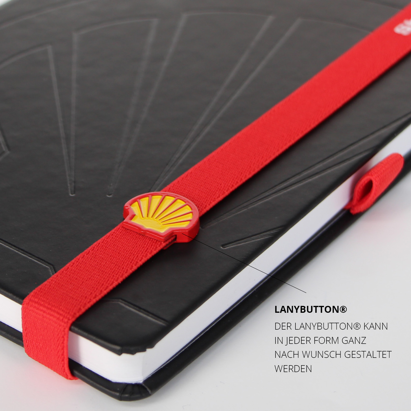Individueller LanyButton® mit Shell-Logo als individueller Verschlussknopf für das Notizbuch.