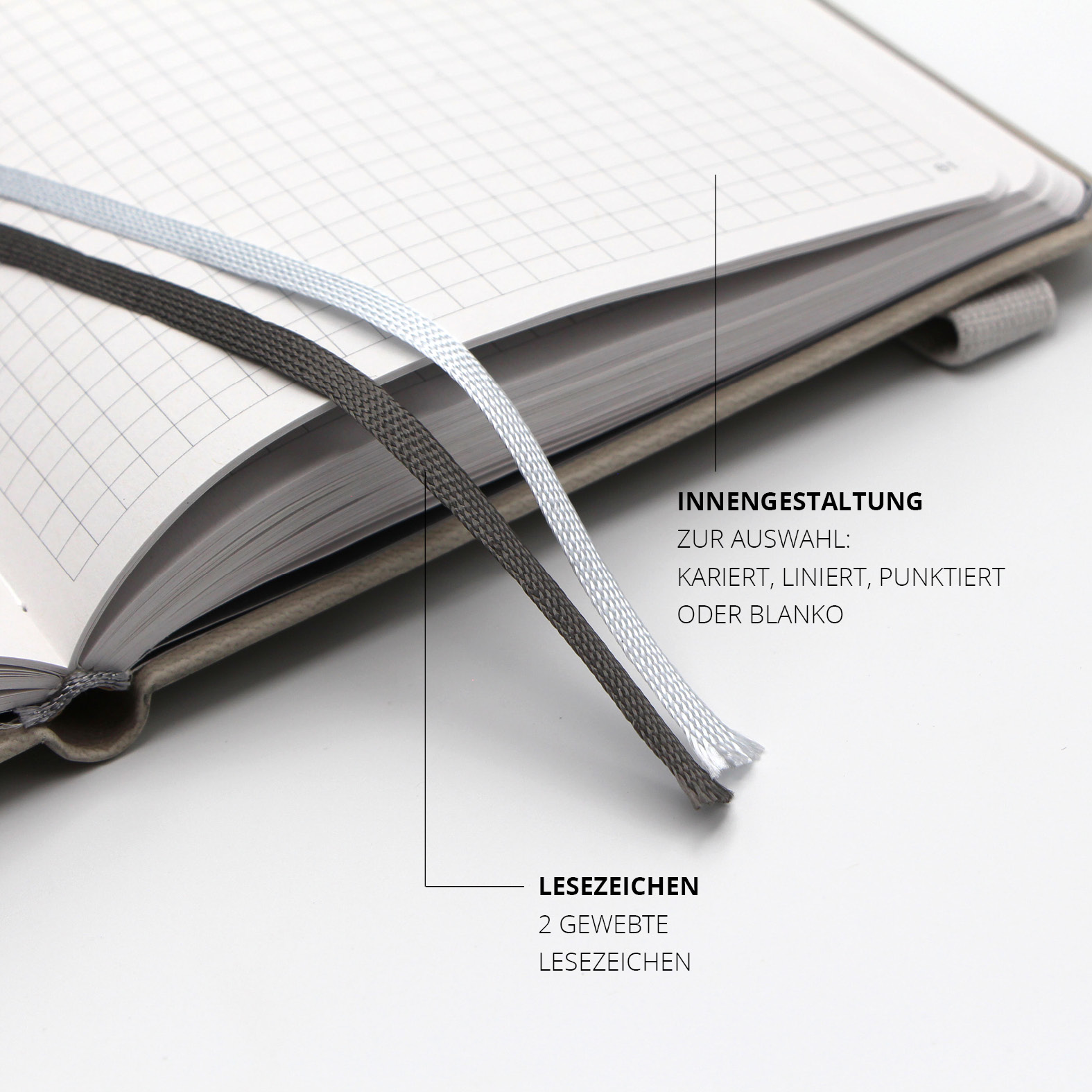 Zwei gewebte Lesezeichen in Grau und Weiß im Inneren des Lanybook® Pro – für eine strukturierte Organisation von Notizen.