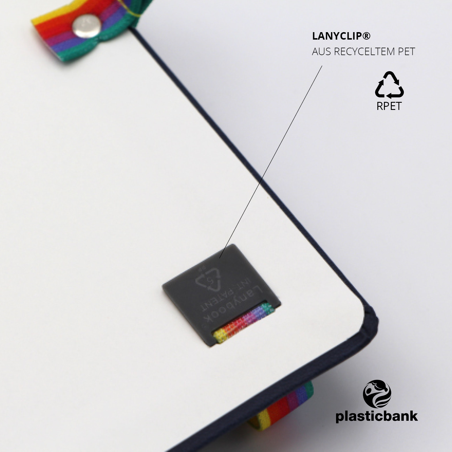 Nahaufnahme des integrierten Lanyclip® aus recyceltem PET, befestigt auf dem hinteren Vorsatzblatt des Lanybooks. Sichtbar ist das Lanybook® Patent-Siegel und ein Stück des bunten Lanybands.