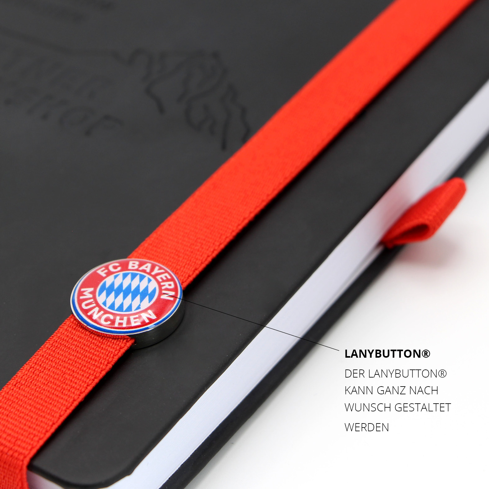 Roter Lanybutton® mit FC Bayern München Logo, mittig platziert auf dem elastischen Lanyband®. Individuell gestaltbares Branding-Element.