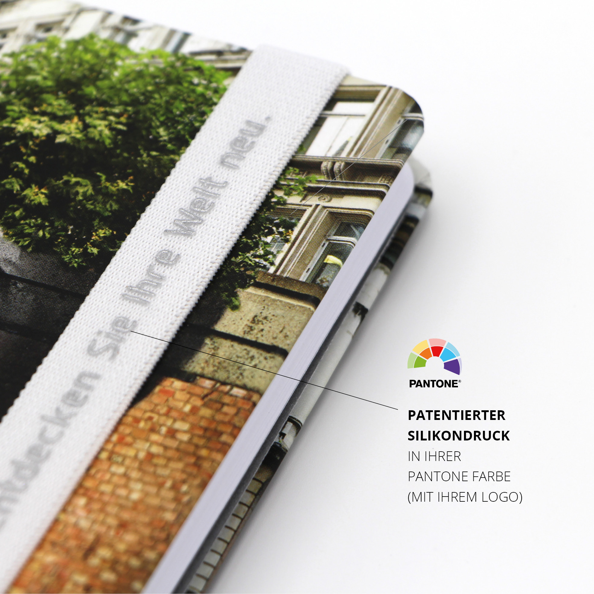 Weißes Lanyband® mit Silikondruck über Cover gespannt, bedruckt mit „Entdecken Sie Ihre Welt neu.“