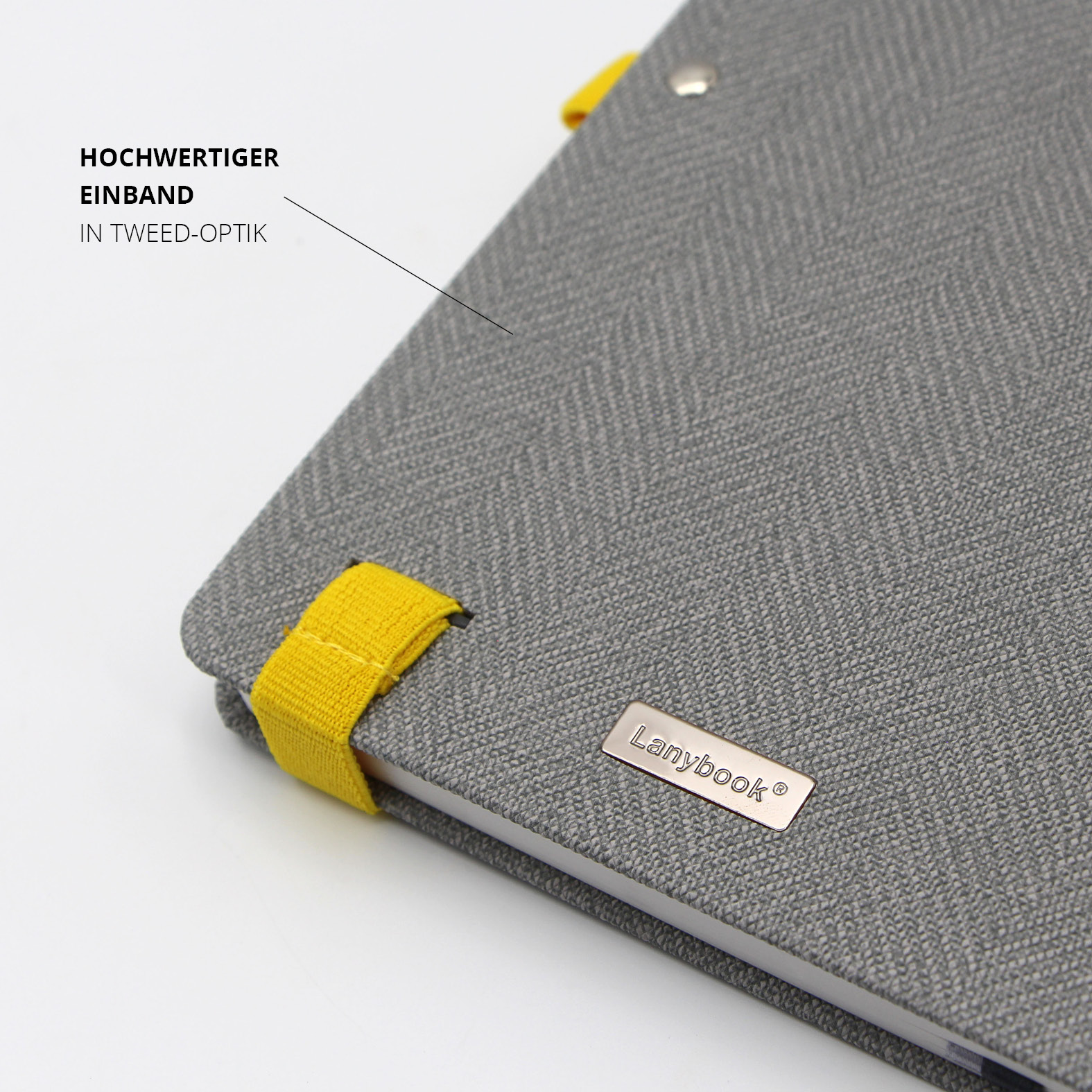 Nahaufnahme des hochwertigen Einbands in grauer Tweed-Optik mit gelben Halterungen und Lanybook® Metalllabel.