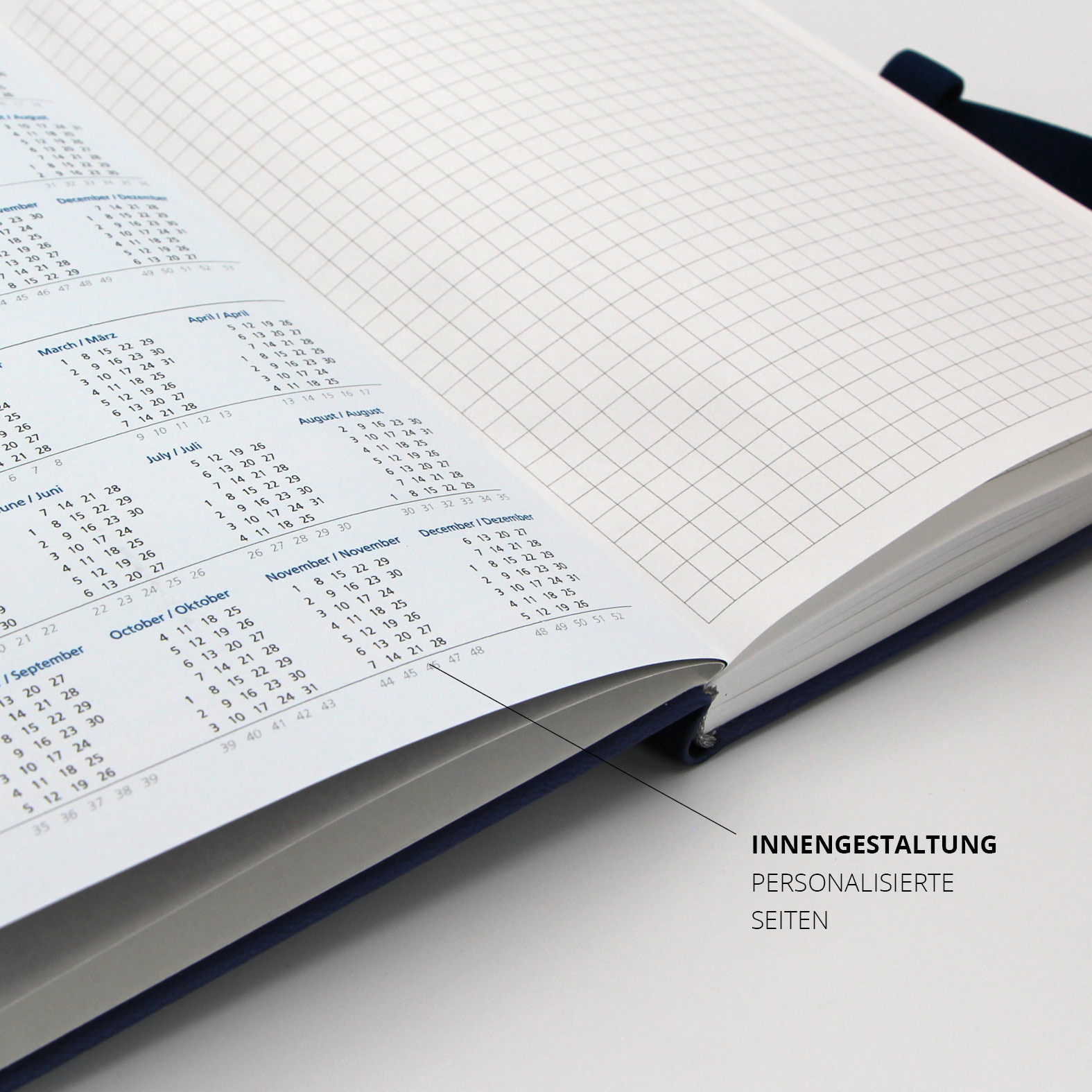 Gedruckter Jahreskalender auf einer personalisierten Innenseite, daneben kariertes Notizpapier.