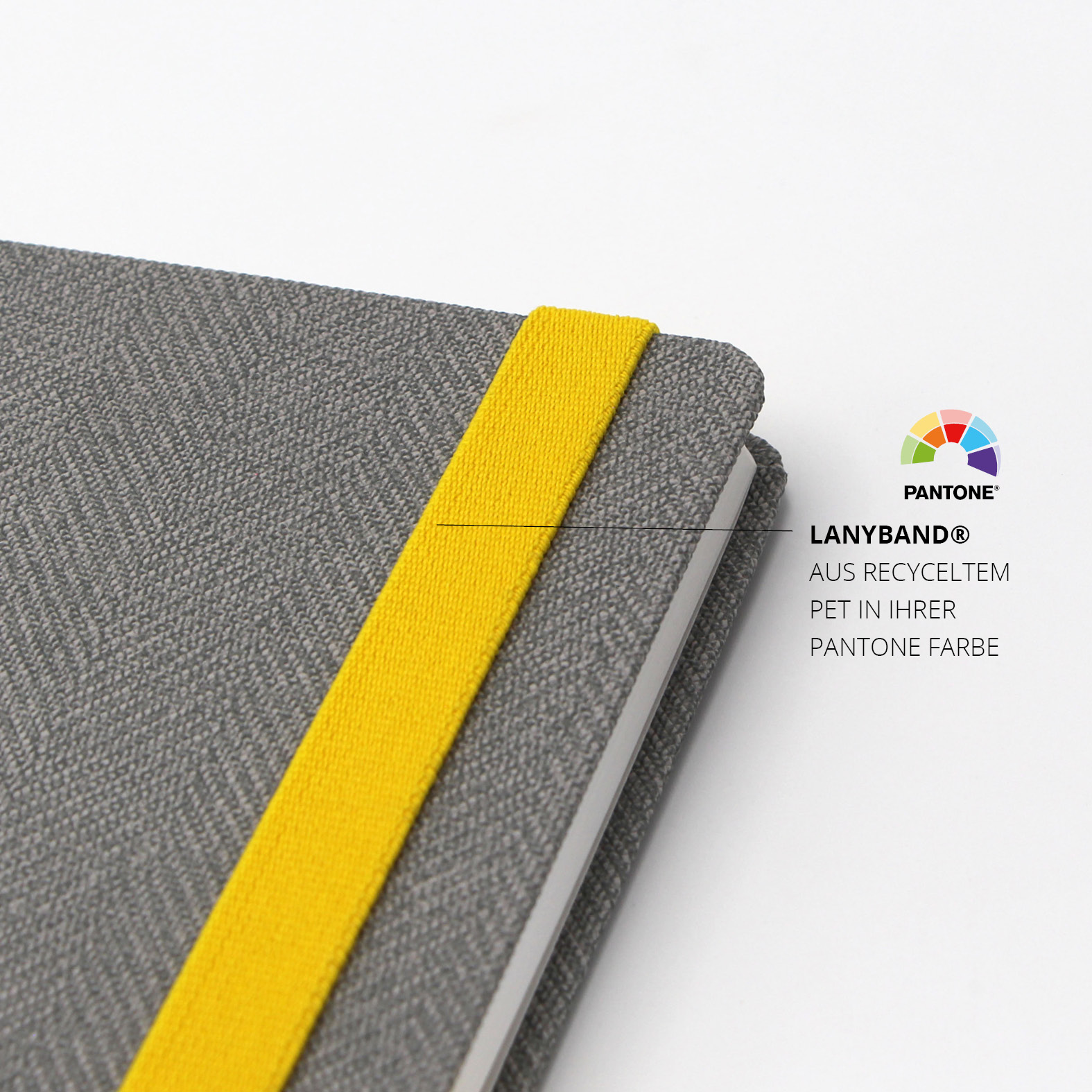 Gelbes Lanyband® aus recyceltem PET in Pantone-Farbe, sauber am grauen Einband eingefasst.