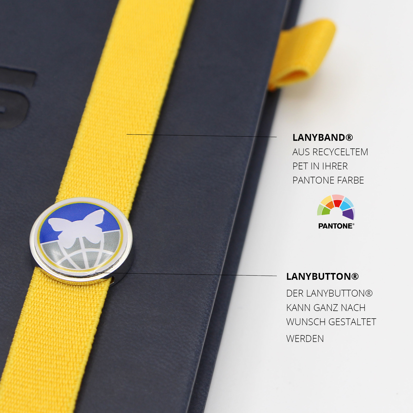 Gelbes Lanyband® aus recyceltem PET mit individuell gestaltetem Lanybutton® im Stiftungsdesign – ein markanter Farbakzent auf dem blauen Cover.