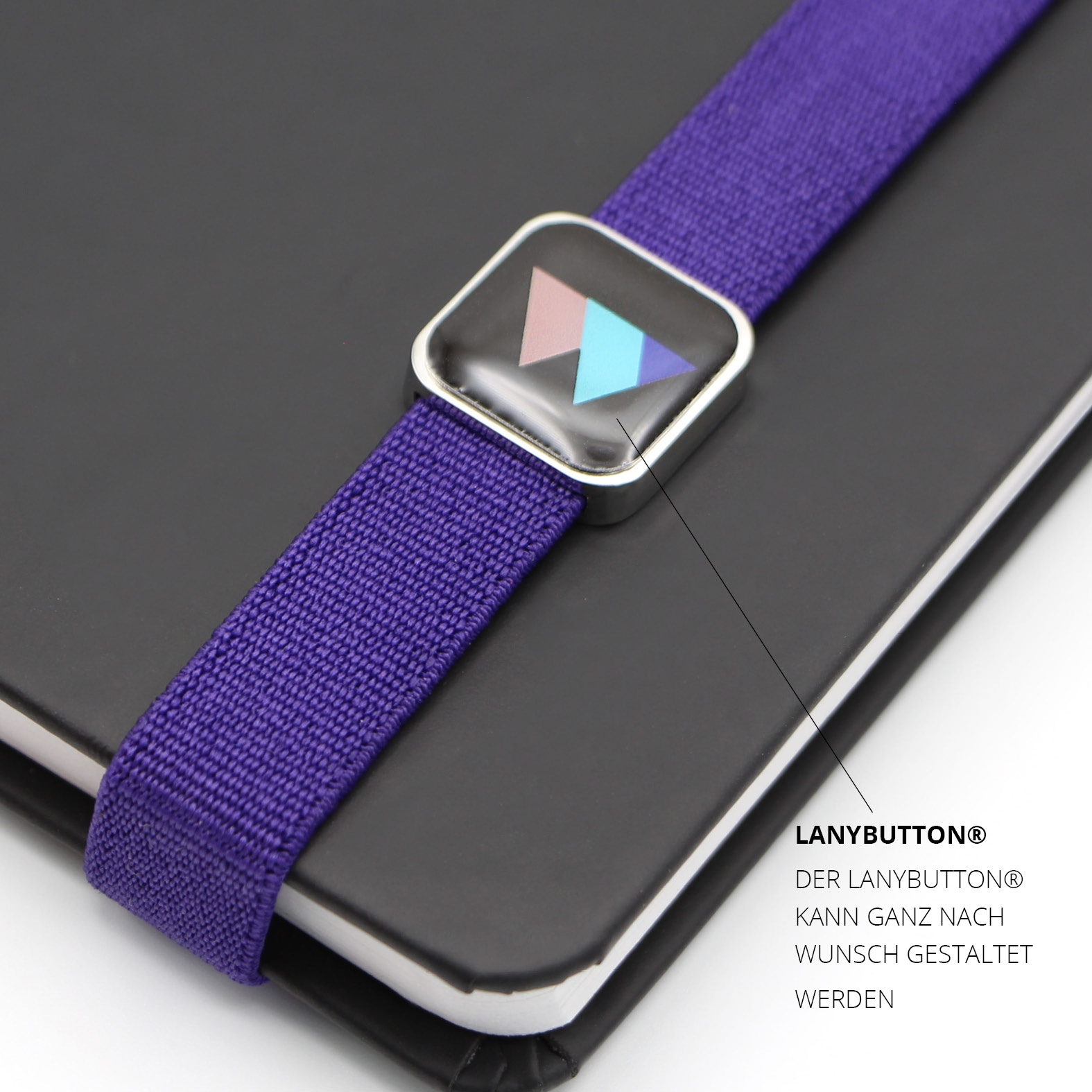 Nahaufnahme des individuell gestalteten Lanybutton® auf dem lila Lanyband. Sichtbar ist das Women in Cyber Switzerland Logo unter transparenter Epoxidharzbeschichtung.