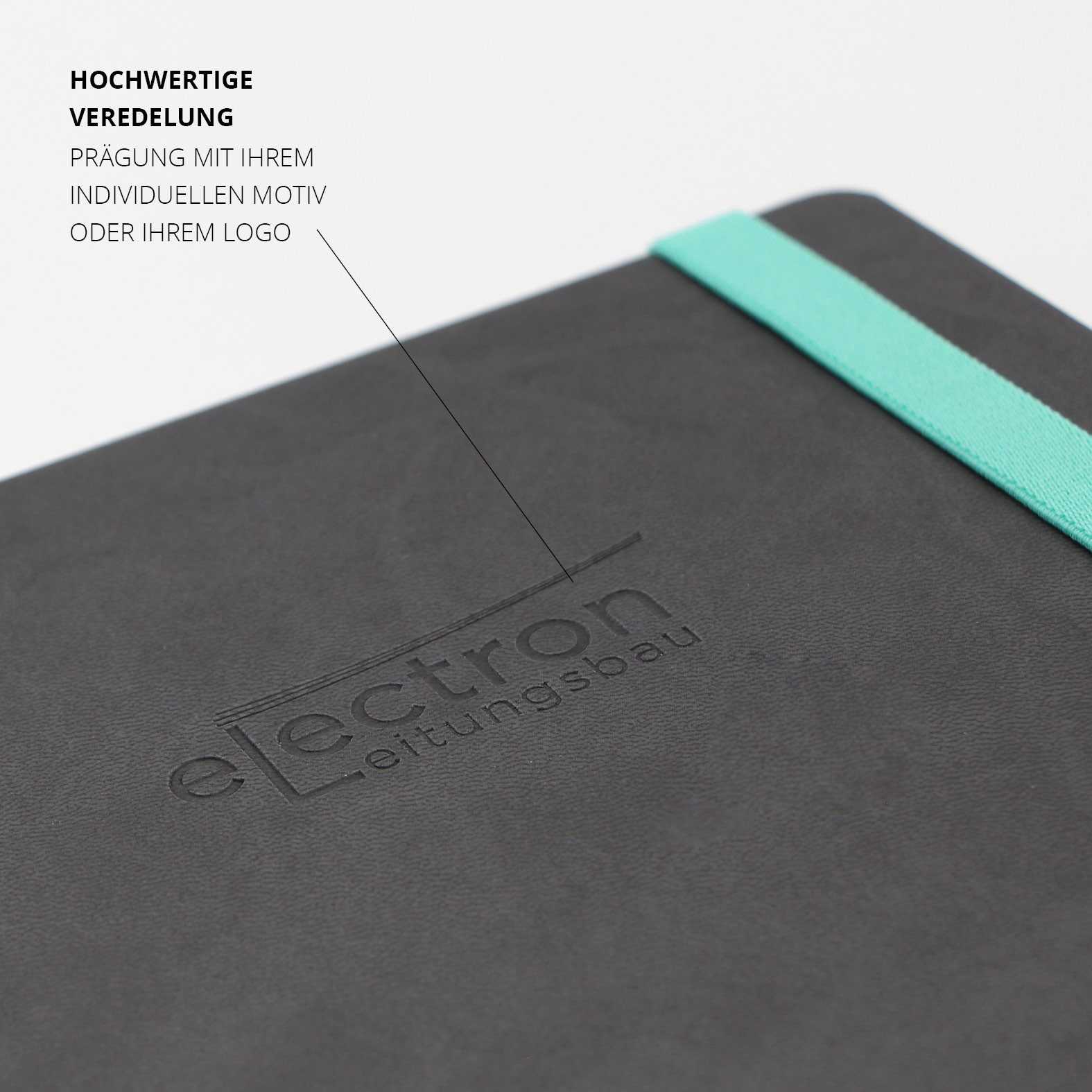 Detailansicht der edlen Blindprägung des „electron leitungsbau“-Logos auf dem mattschwarzen Cover mit türkisfarbenem Lanyband®.