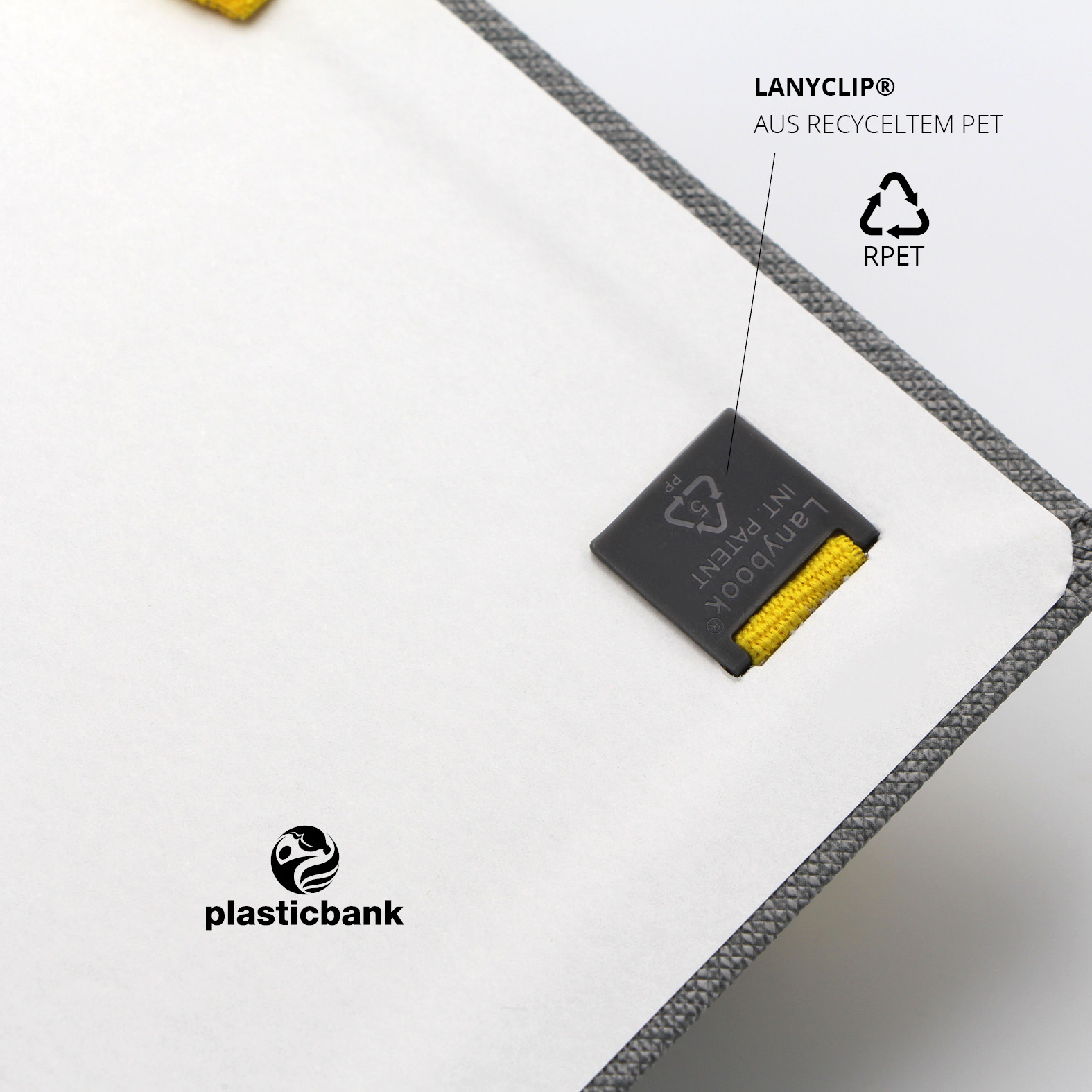 Schwarzer Lanyclip® aus recyceltem PET (rPET), innen befestigt am Notizbuch, mit geprägtem Lanybook® Patent-Hinweis.