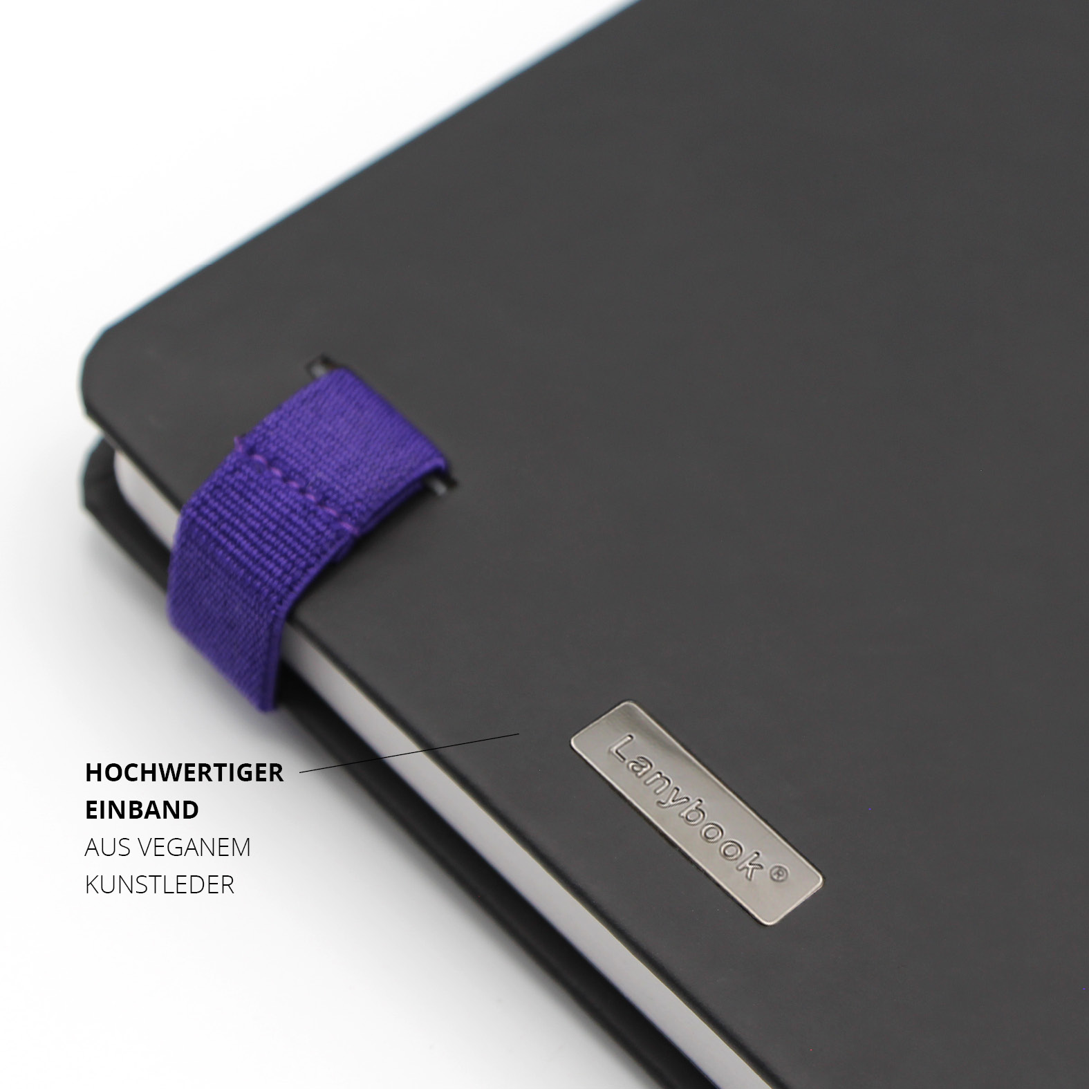 Detailaufnahme des hochwertigen Lanybook® Covers aus veganem Kunstleder mit lila Stiftschlaufe und metallischer Markenplakette auf der Rückseite.